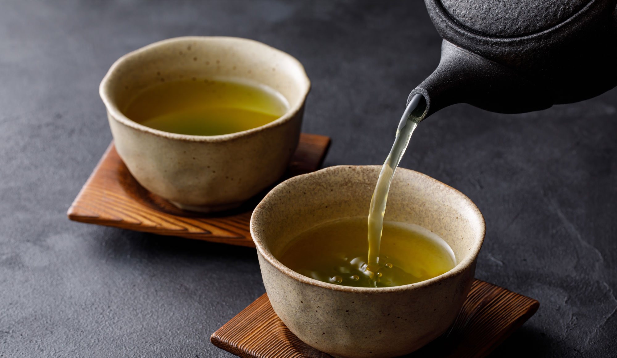 湯気の立つ緑茶の湯のみ。秋の養生のイメージ。